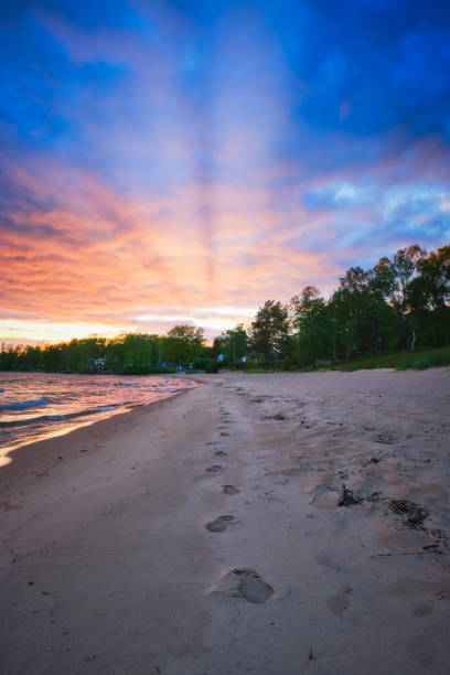 istock footprints on a beach with colorful clouds and sunset in the background 1158253498