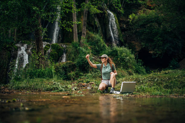 mujer tomando una muestra de agua - conservacionista fotografías e imágenes de stock