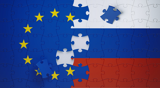 Jigsaw puzzle pieces textured with European Union and Russian flags. Horizontal composition with copy space and selective focus. Solution concept.