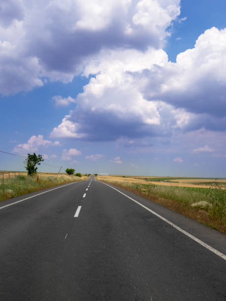 istock Long asphalt road and sea with cloud and sky 1158254825