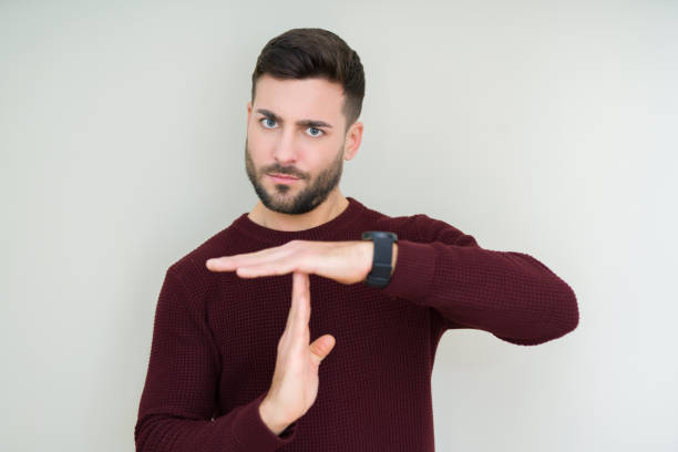 istock Young handsome man wearing a sweater over isolated background Doing time out gesture with hands, frustrated and serious face 1158256662