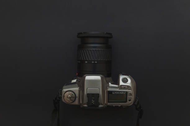 Photographer workplace with dslr camera system on dark black table background. Hobby travel photography concept