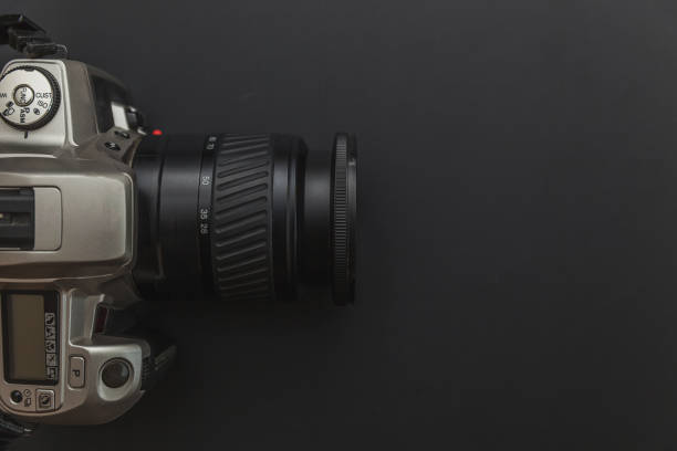 istock Photographer workplace with dslr camera system on dark black table background. Hobby travel photography concept 1158258593