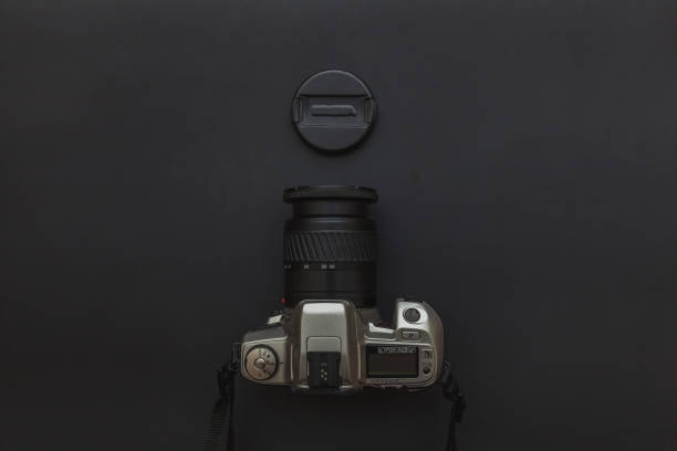 istock Photographer workplace with dslr camera system on dark black table background. Hobby travel photography concept 1158258695
