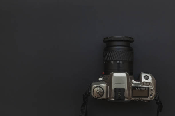 istock Photographer workplace with dslr camera system on dark black table background. Hobby travel photography concept 1158258704