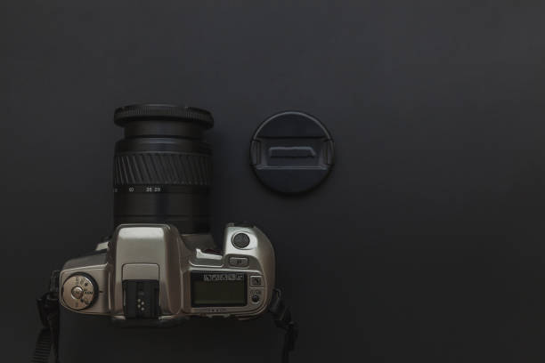 istock Photographer workplace with dslr camera system on dark black table background. Hobby travel photography concept 1158258803