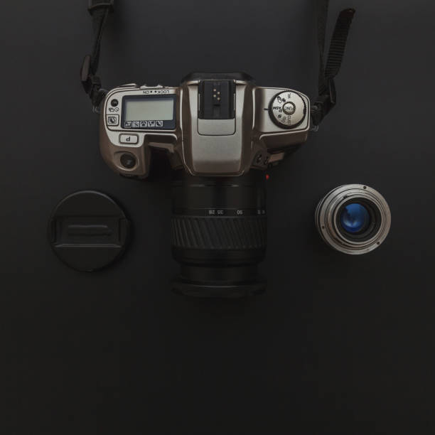 istock Photographer workplace with dslr camera system and lens on dark black table background. Hobby travel photography concept 1158258883