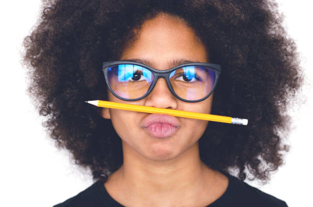 Dark-skinned girl with glasses holding a simple pencil.