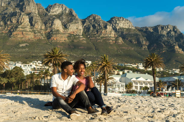 istock Loving young couple sitting on sand at beach 1158261041