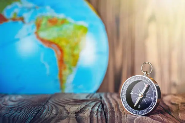 Travel compass and earth globus on wooden background. Journey, adventure lifestyle.Road to home.Trip.