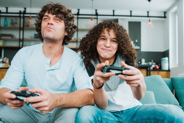 istock Father and son playing digital games at home 1158268033