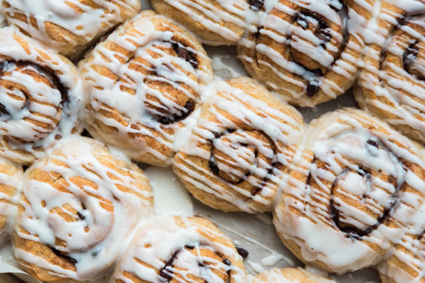 Diagonal rows of cinnamon rolls drizzled with icing