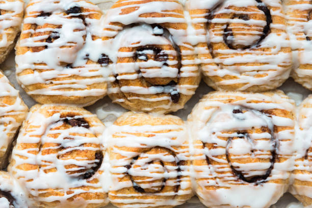 Close-up of homemade vegan cinnamon rolls in pan and drizzled with vanilla frosting