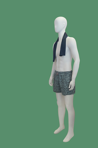 Full-length male mannequin dressed in shorts, isolated on green background.  No brand names or copyright objects.