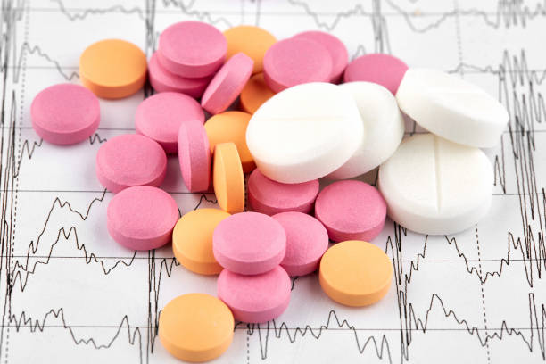 istock Pink, orange and white pills on EKG graph 1158270773