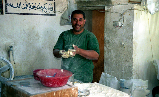 Iraq, Baghdad - 2 may 2005 A man prepares food from dough