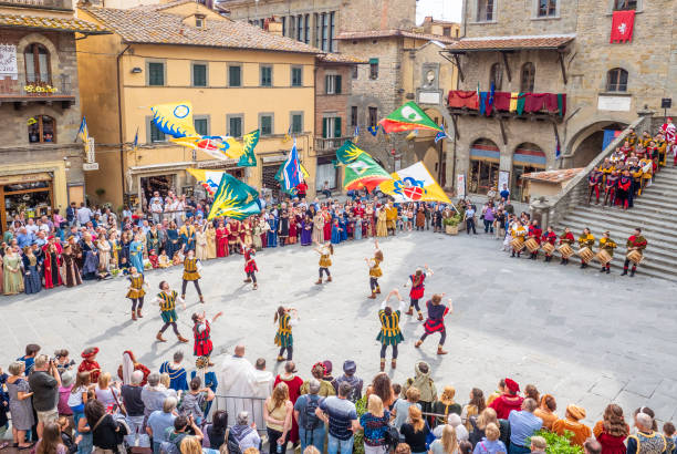 Cortona (Tuscany, Italy) Cortona, Italy - 25 May 2019 - The awesome historical center of the medieval and renaissance city on the hill, Tuscany region, province of Arezzo, during the spring. Here in particular the central square with flag bearers in costumes cortona stock pictures, royalty-free photos & images