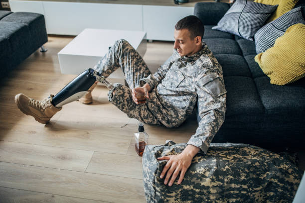 istock Depressed soldier with prosthetic leg drinking whiskey 1158273809