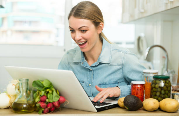 istock Young woman cooking recipe from the Internet 1158274621