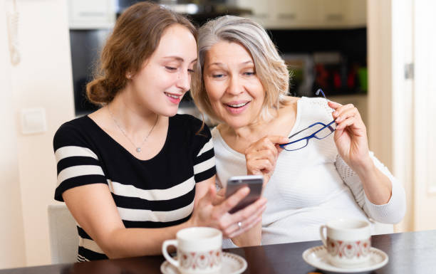 istock Mother with daughter using smartphone 1158275060