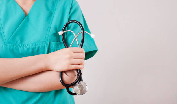 istock Doctor holding a stethoscope on gray background 1158276359