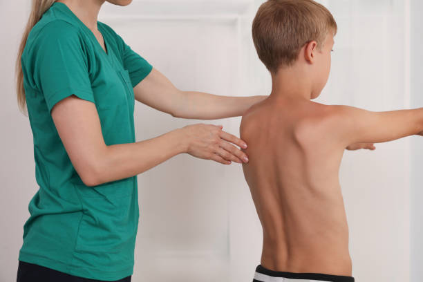 istock Child having chiropractic back adjustment. Osteopathy, Physiotherapy, Kinesiology. Bad posture correction 1158276966