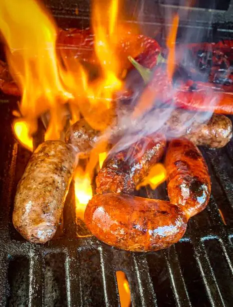 Sausages with smoke and fire on barbecue