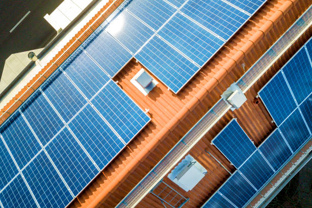 aerial view of solar photo voltaic panels system on apartment building roof. renewable ecological green energy production concept. - voltaic imagens e fotografias de stock