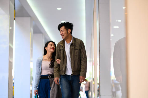 istock Couple with arm in arm walking by stores 1158288991