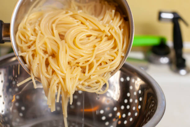 draining spaghetti - salatsieb stock-fotos und bilder