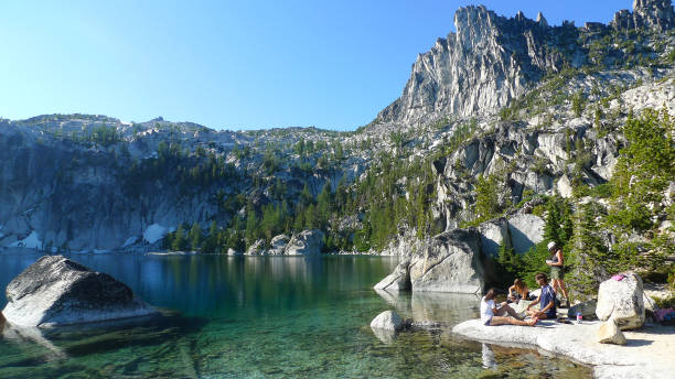 Leavenworth, Washington - August 27th, 2011: Hikers taking a break on lake Viviane of Enchantment Lakes Trail with Prusik Peak in Leavenworth Washington USA.