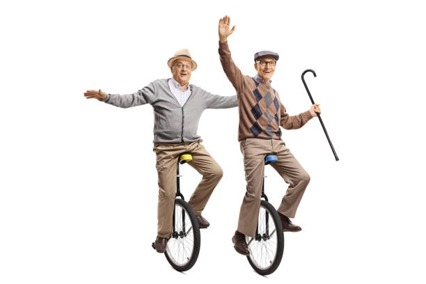 istock Two cheerful senior men riding unicycles 1158298183