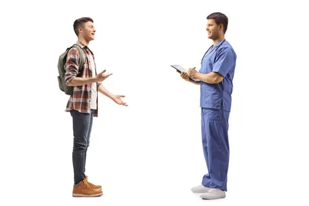 Photo of Male student talking to a health pratctitioner in a blue uniform