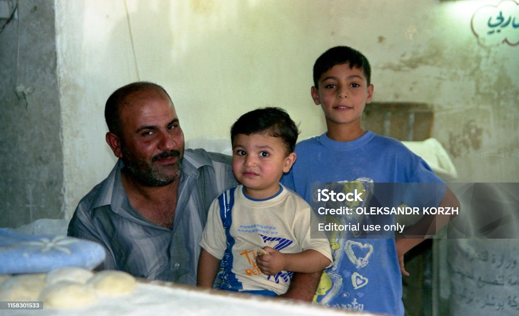 Muslim people Iraq, Baghdad - 2 may 2005 Father and two sons in the kitchen near the wall Family Stock Photo