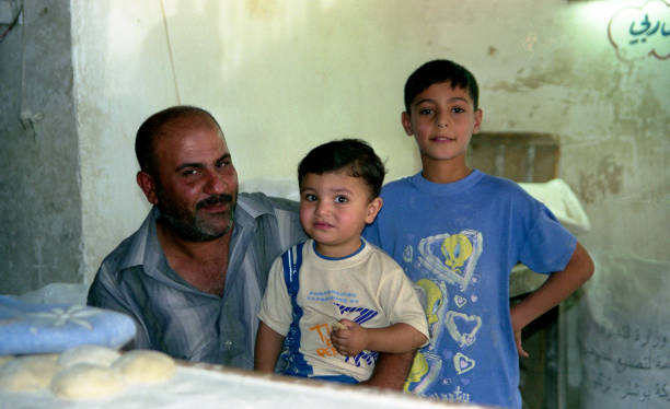 Muslim people Iraq, Baghdad - 2 may 2005 Father and two sons in the kitchen near the wall moroccan culture photos stock pictures, royalty-free photos & images