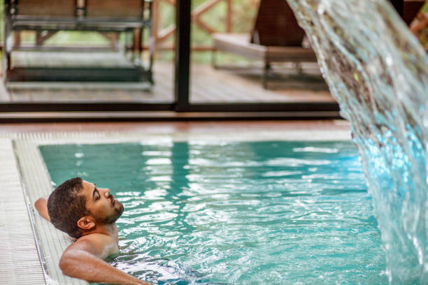 istock Young mixed race man enjoying in pool 1158304522