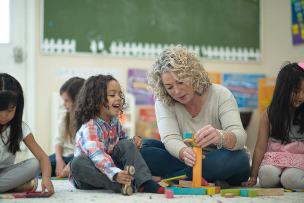istock Caucasian female teacher playing blocks with her students 1158305193