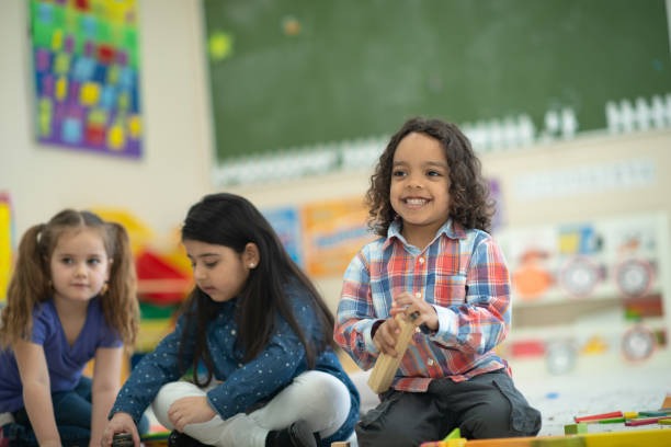 istock Ethnic boy in preschool smiling while holding a block in his hand 1158305202