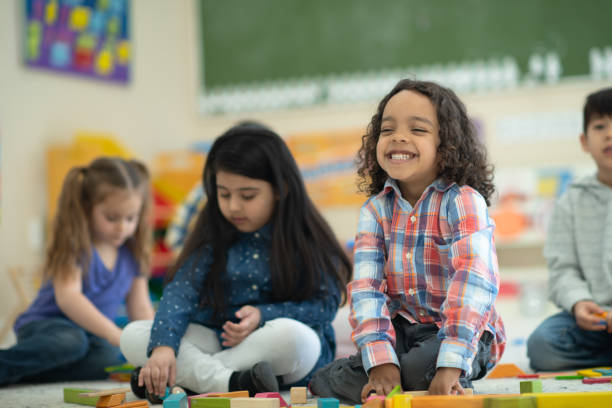 istock Ethnic boy in preschool smiling while holding a block in his hand 1158305203