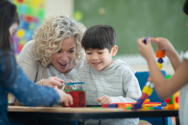 istock Caucasian teacher plays magnetic blocks with her ethnic student 1158305224