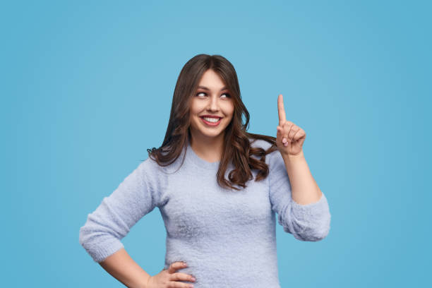 istock Happy woman pointing up 1158305257