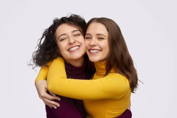 Best friends hugging and cheerfully smiling stock photo