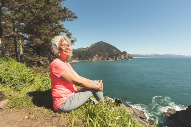 senior woman hiking on the oregon coast - old dirt road imagens e fotografias de stock