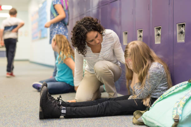 istock A teacher consoling a left-out student at an elementary school 1158306765