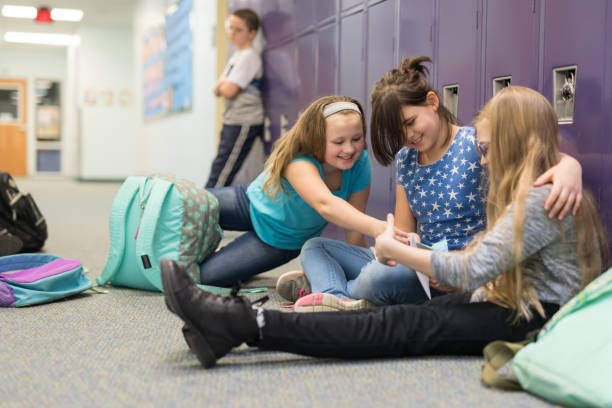 istock Two friends consoling their other friend at an elementary school 1158306770