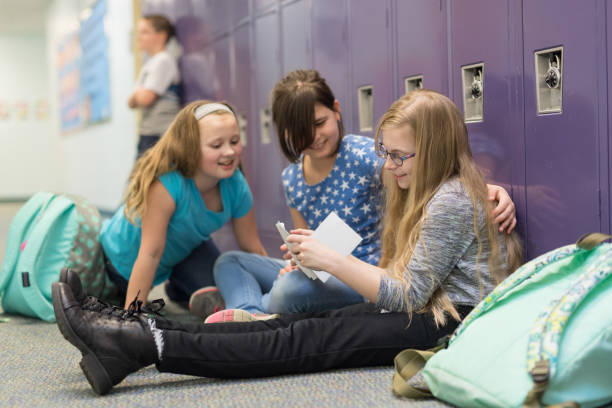 istock Two friends consoling their other friend at an elementary school 1158306773
