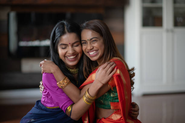 zwei (2) glückliche und attraktive indische schwestern - praying joy indoors lifestyles stock-fotos und bilder