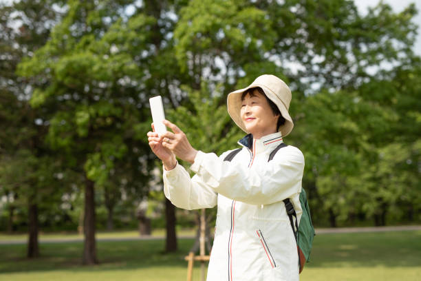 istock Senior woman taking selfie in tree area 1158309877