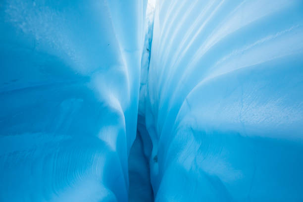 Textured lines leading down into a crevasse. Ice structure and line background from an ice cave.
