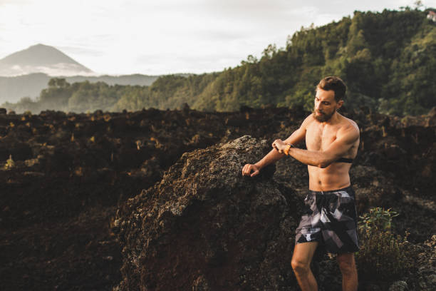 istock Athletic man checking running route on smart watch or fitness tracker before run. Training topless. Trail running outdoors. 1158317150